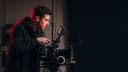 A content producer checking a cinema camera monitor on a darkened set