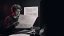 A web writer comparing two printed page proofs in a darkened studio